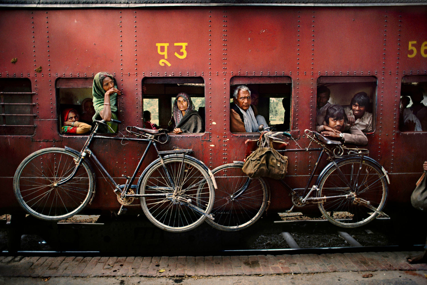 Alle Fotos © Steve McCurry” “aus Indien (Prestel Verlag, 2015)” Westbengalen, 1983. Fahrräder hängen an der Aussenwand eines Eisenbahnwaggons.